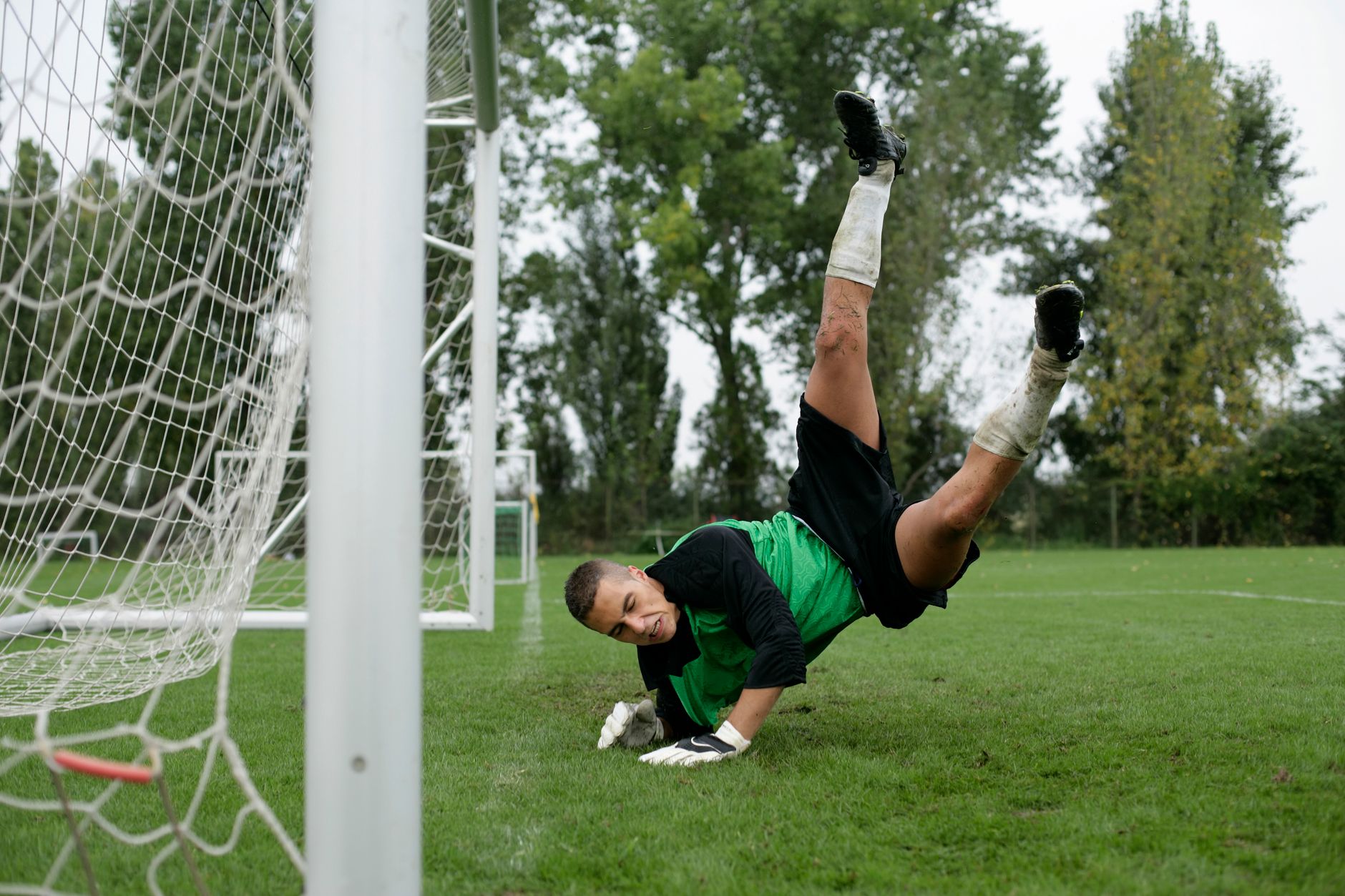 goalkeeper diving to save football on field