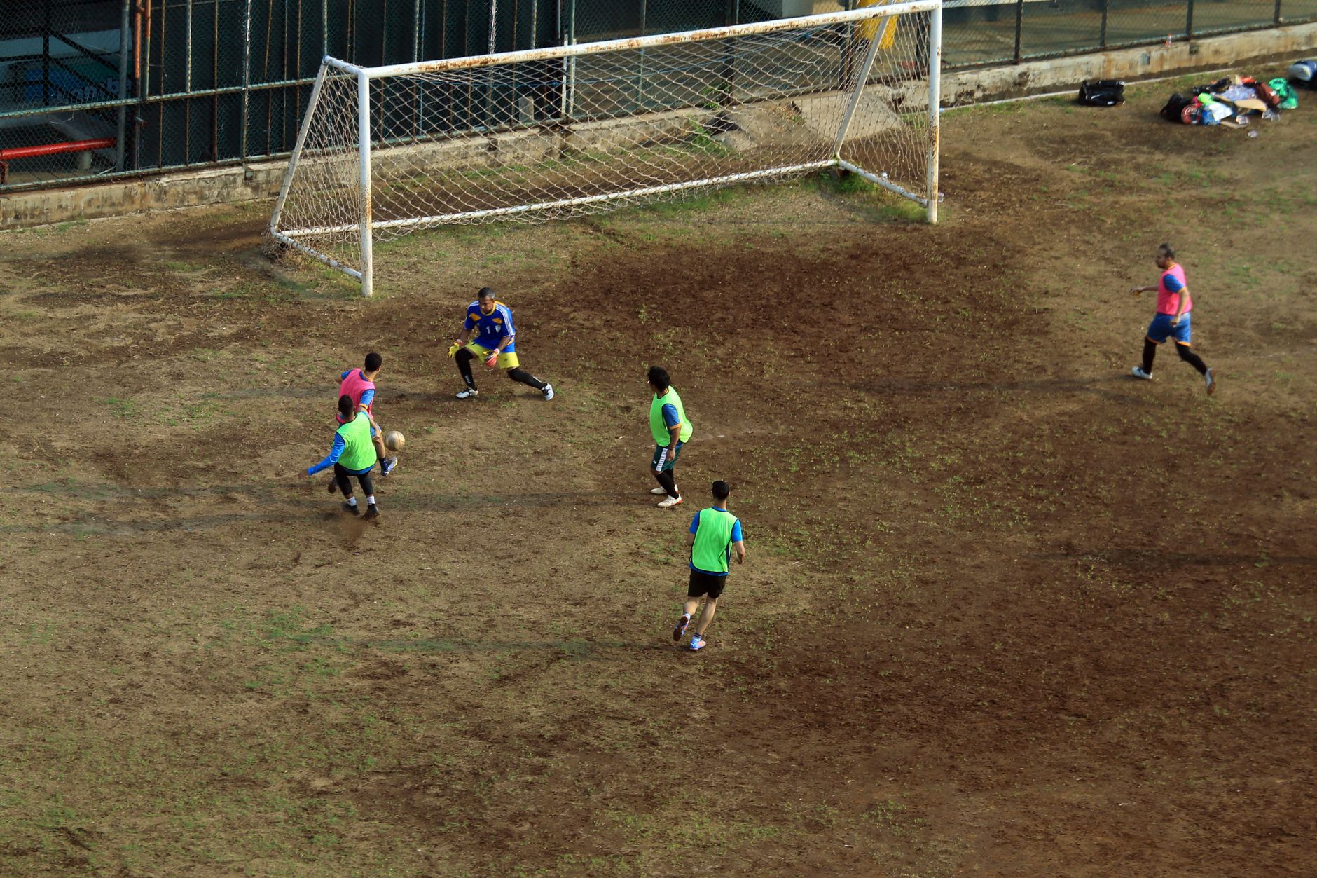 football players battling for ball on muddy field